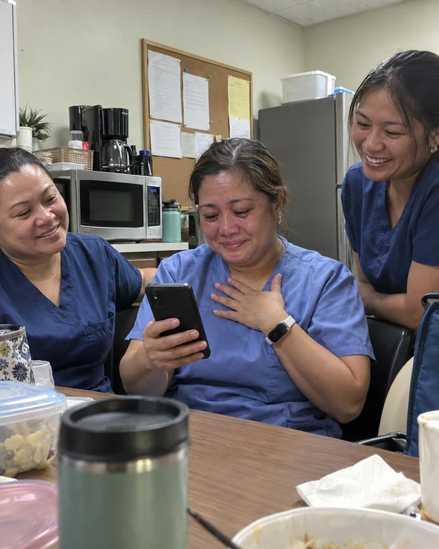 A nurse in scrubs holds her phone and presses a hand to her chest with happy tears as two coworkers smile beside her (AI photo, fictional people)