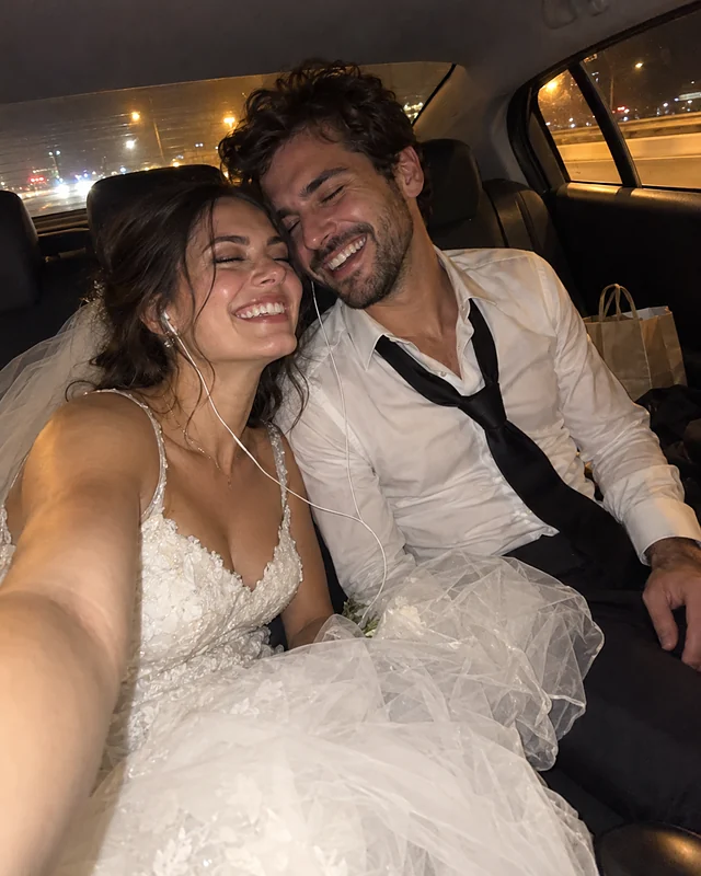Newlyweds sharing a pair of earbuds in the back seat of a car at night, laughing with their eyes closed, a crumpled veil on her lap (AI photo, fictional people)